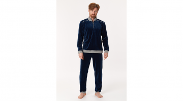 Deze Woody heren Pyjama van soepel, warme donkerblauwe velours is heel aangenaam en comfortabel om dragen. Deze Woody homewear set bestaat uit jas met lange mouwen en korte rits, en een lange broek. Beiden met grijze contrastboord. Draag deze als Pyjama
